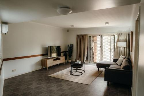 a living room with a couch and a table at Unit 1, Rocky CBD in Rockhampton