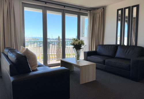 a living room with a couch and a table with a vase of flowers at Bluewater Hotel in Napier