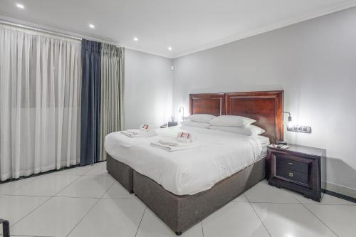 a bedroom with a large bed with a wooden headboard at Moyres Guest House in Witbank