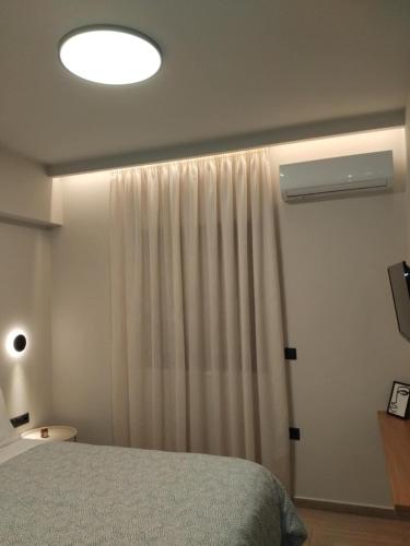 a bedroom with a bed and a white curtain at Simple, Calm and Luxurious in Kalamata