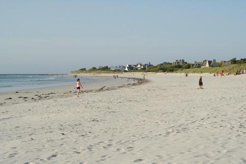 a group of people walking on the beach at Villa le Nid Des Dunes & Spa 2 gîtes écologiques in Santec