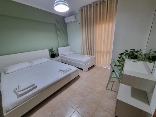 a bedroom with a white bed and a chair at KC Apartment 1 in Berat