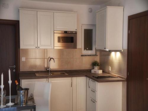 a kitchen with white cabinets and a sink at Apartments Maritea in Vodice