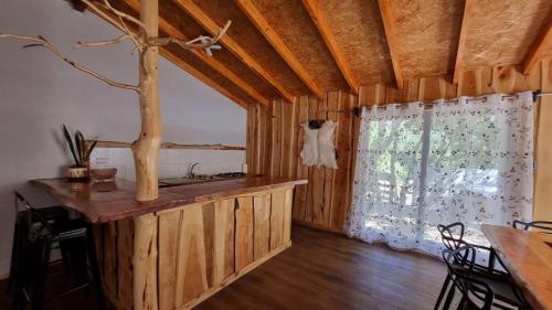 a room with a kitchen with a counter and a window at Cabaña familiar en el campo a 15 minutos del centro de Melipeuco in Rumiñano
