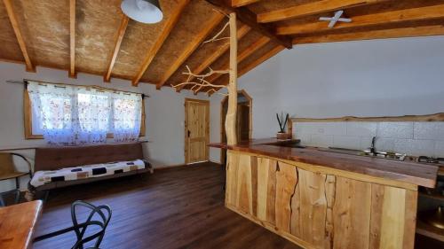 a large kitchen with wooden floors and wooden ceilings at Cabaña familiar en el campo a 15 minutos del centro de Melipeuco in Rumiñano