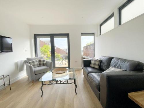 a living room with a couch and a table at Stylish and private in the Cathedral Quarter in Lincoln