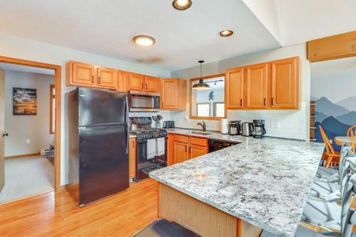 a kitchen with wooden cabinets and a stainless steel refrigerator at 7 Mi to Big Boulder Mtn Poconos Chalet with Hot Tub in Albrightsville