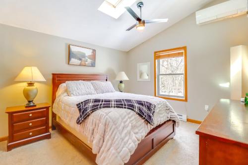 a bedroom with a bed and a ceiling fan at 7 Mi to Big Boulder Mtn Poconos Chalet with Hot Tub in Albrightsville