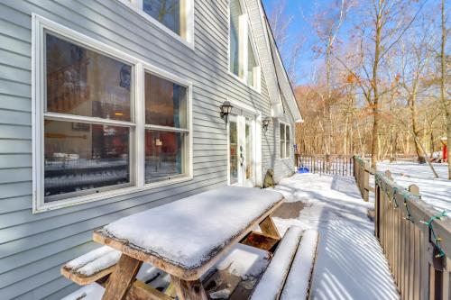 a bench sitting outside of a house in the snow at 7 Mi to Big Boulder Mtn Poconos Chalet with Hot Tub in Albrightsville
