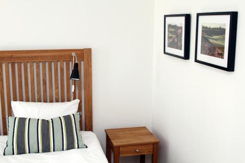 a bedroom with a bed and three pictures on the wall at Sand Golf Club in Bankeryd