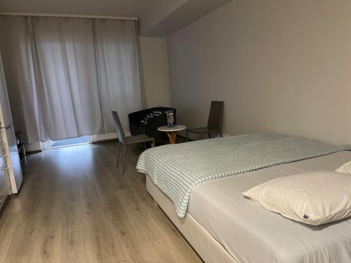 a bedroom with a bed and a table and chairs at Modern furnished studio in Martinkylä