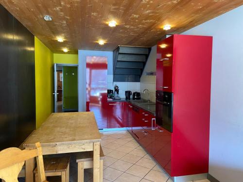 a kitchen with a wooden table and a red refrigerator at Chalet Fleur des Alpes 1 in Les Gets
