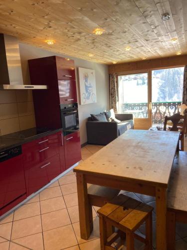a kitchen and living room with a wooden table at Chalet Fleur des Alpes 1 in Les Gets