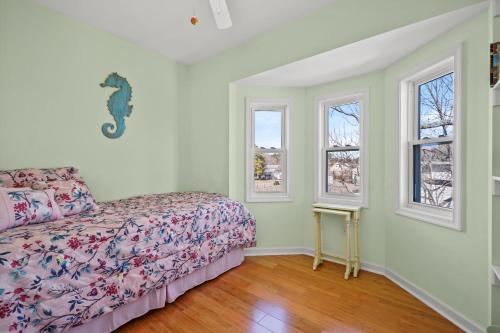a bedroom with a bed and two windows at Olive Ponies - Upper level with water Views! in Birch Town