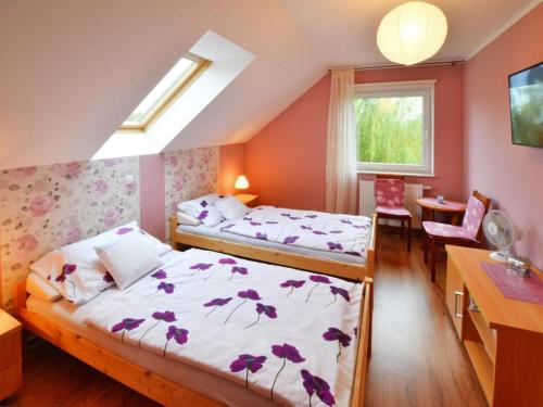 ein Schlafzimmer mit zwei Betten und einem Schreibtisch und einem Fenster in der Unterkunft Holiday apartment, 2 bedrooms, garden, bicycles in Radzikowo