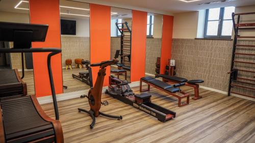 a gym with several treadmills and exercise equipment at DAS KEHRS - Hotel auf dem Petersberg in Erfurt