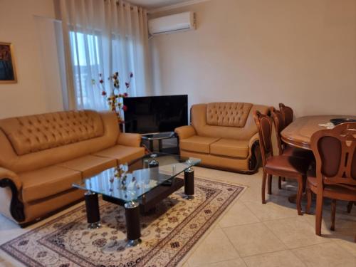 a living room with a couch and a table and chairs at KC Apartment 1 in Berat