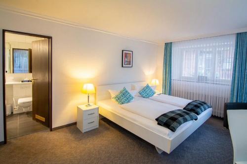 a hotel room with a bed and a bathroom at Hotel Adler - Weil am Rhein in Weil am Rhein