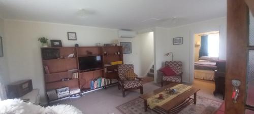 a living room with a couch and a table at Kowhai Cottage Whanganui in Whanganui