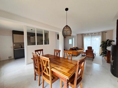 - une salle à manger et un salon avec une table et des chaises en bois dans l'établissement La Belle Villès, à La Ville-ès-Nonais