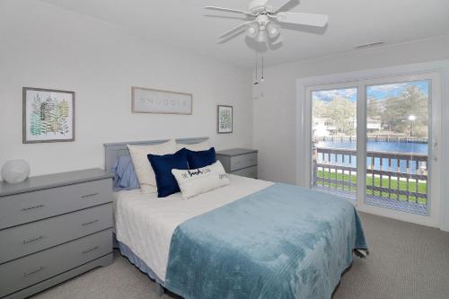 a bedroom with a bed with a ceiling fan and a window at Our Happy Place - Pet friendly & waterfront! in Deep Hole