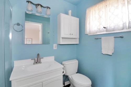 a bathroom with a toilet and a sink and a mirror at Our Happy Place - Pet friendly & waterfront! in Deep Hole