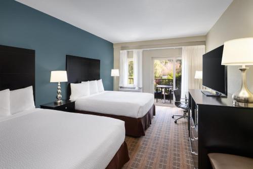 a hotel room with two beds and a television at La Cuesta Inn, BW Signature Collection in San Luis Obispo