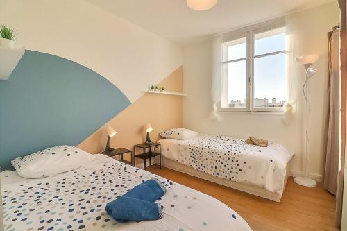 une chambre avec deux lits et une fenêtre dans l'établissement Nyméria, à Nîmes