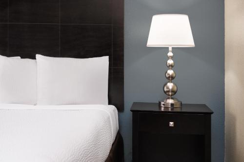 a lamp on a night stand next to a bed at La Cuesta Inn, BW Signature Collection in San Luis Obispo