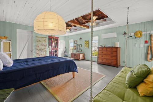 a bedroom with a blue bed and a couch at Oyster Catcher - Pet friendly & deep water access! in Deep Hole