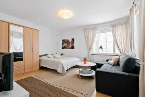 a living room with a couch and a bed at Majoitushuoneisto Tuomipuisto in Naantali