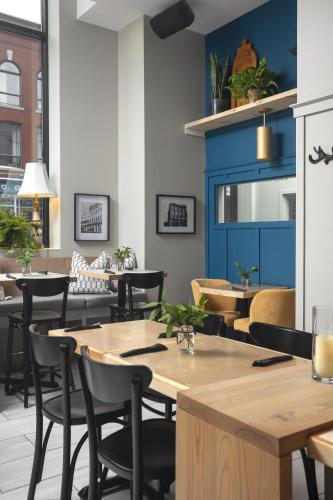a restaurant with tables and chairs and a blue wall at Hotel Oui GO! in Trois-Rivières