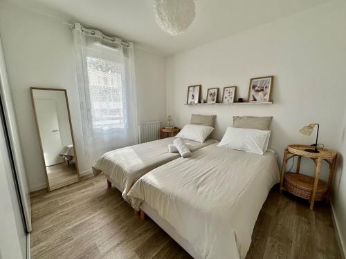 une chambre blanche avec un grand lit et un miroir dans l'établissement Petit havre de paix !, à Carcans