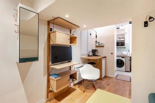 Cette chambre comprend un bureau, une télévision et une chaise. dans l'établissement Cosy Duplex in Central Paris, à Paris