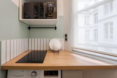 Il comprend une cuisine équipée d'un four micro-ondes et d'un comptoir en bois. dans l'établissement Cosy Duplex in Central Paris, à Paris