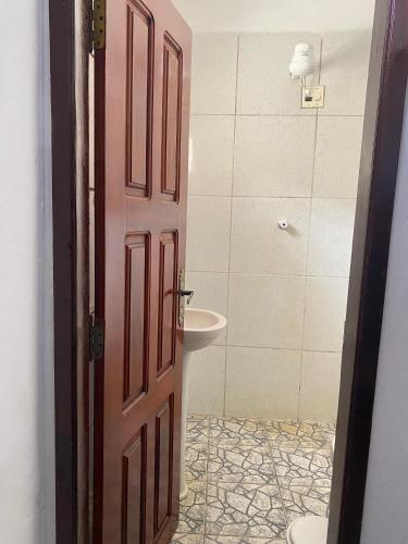 a bathroom with a toilet and a sink and a door at Residence Brisa in Jericoacoara