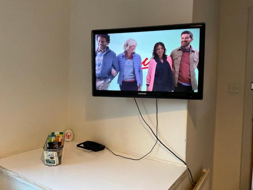 a flat screen tv hanging on a wall at Private Rooms with Shared Bathroom Bus Stop 8 Mins Away in Earley