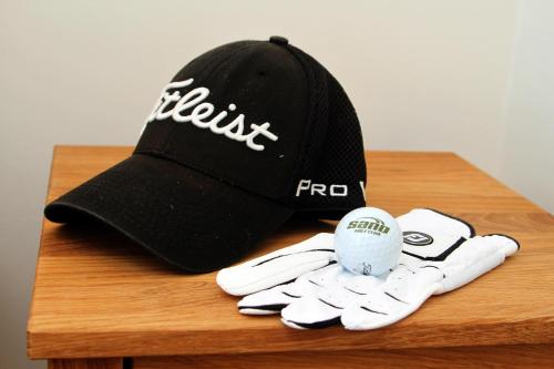 a baseball cap and gloves on a wooden table at Sand Golf Club in Bankeryd