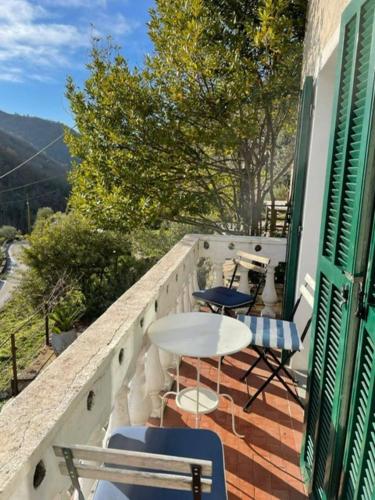 a balcony with chairs and a table on a building at Casale in campagna ristrutturato in Apricale