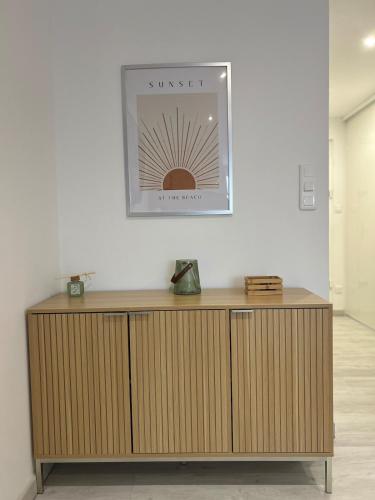 une armoire en bois dans une pièce avec une photo sur le mur dans l'établissement Cozy studio Carnon Plage, à Mauguio