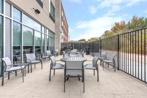 a patio with tables and chairs on a building at Holiday Inn Express & Suites Austin Airport East by IHG in Austin
