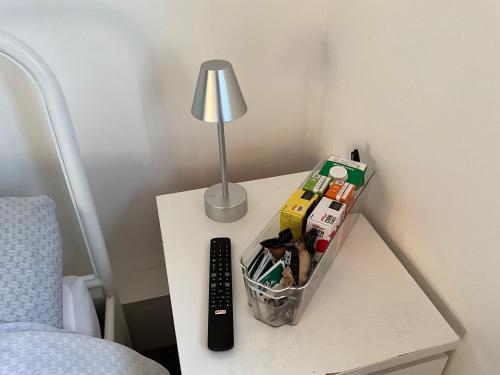 a table with a lamp and a remote control at Private Rooms with Shared Bathroom Bus Stop 8 Mins Away in Earley