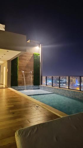 a swimming pool in a building with a view of the city at Central Relax Apartment in Encarnación