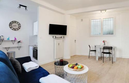 un salon avec un canapé bleu et une table dans l'établissement Charming Studio - 2P - Sacré Coeur, à Paris