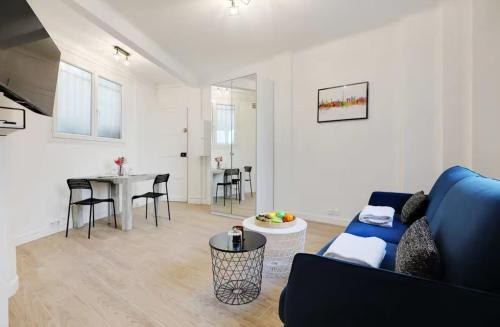 un salon avec un canapé bleu et une table dans l'établissement Charming Studio - 2P - Sacré Coeur, à Paris