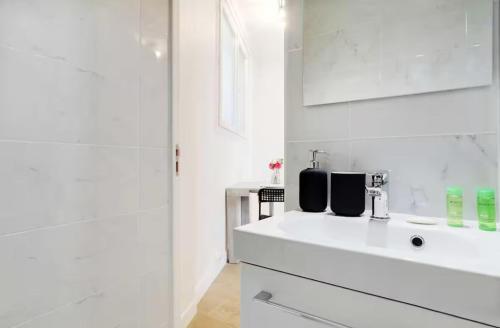 une salle de bain blanche avec un lavabo et une douche dans l'établissement Charming Studio - 2P - Sacré Coeur, à Paris