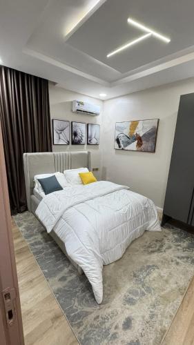 una camera da letto con un grande letto bianco di Triangle a Lekki