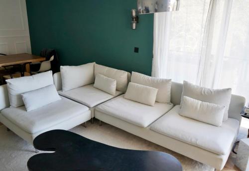 un salon avec un canapé blanc avec des oreillers dans l'établissement T2 Appartement 55m2 Terrasse 20m2 - à 15min à pied du Centre Ville - Wifi - Air conditioning, à Cannes