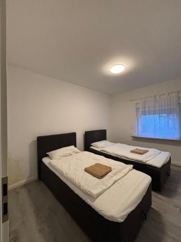 two twin beds in a room with a window at TopLageDG in Augsburg