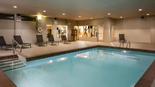 a large swimming pool in a room with chairs at Hyatt Place Oklahoma City Bricktown in Oklahoma City